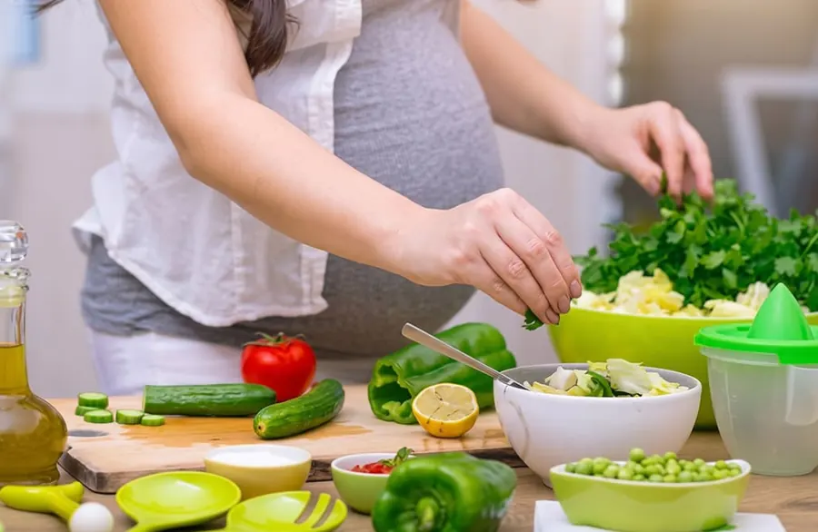 Pregnant mother preparing a fresh salad
